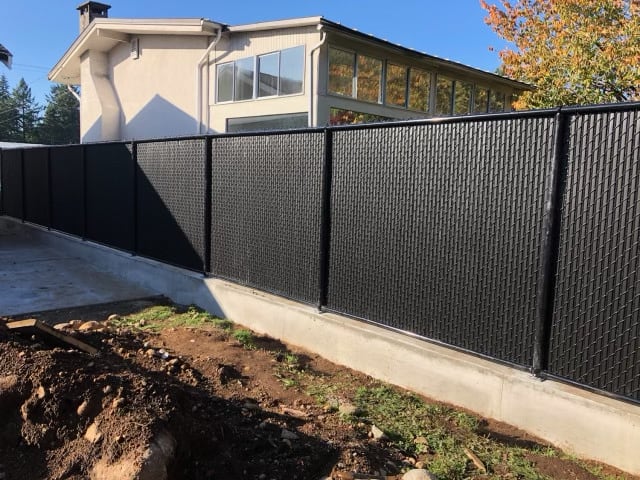 Black privacy slats installed in chain link fence for enhanced privacy and security